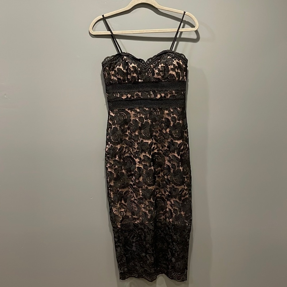Gorgeous, fitted black lace dress. Nude lining with peekaboo hem and waist.